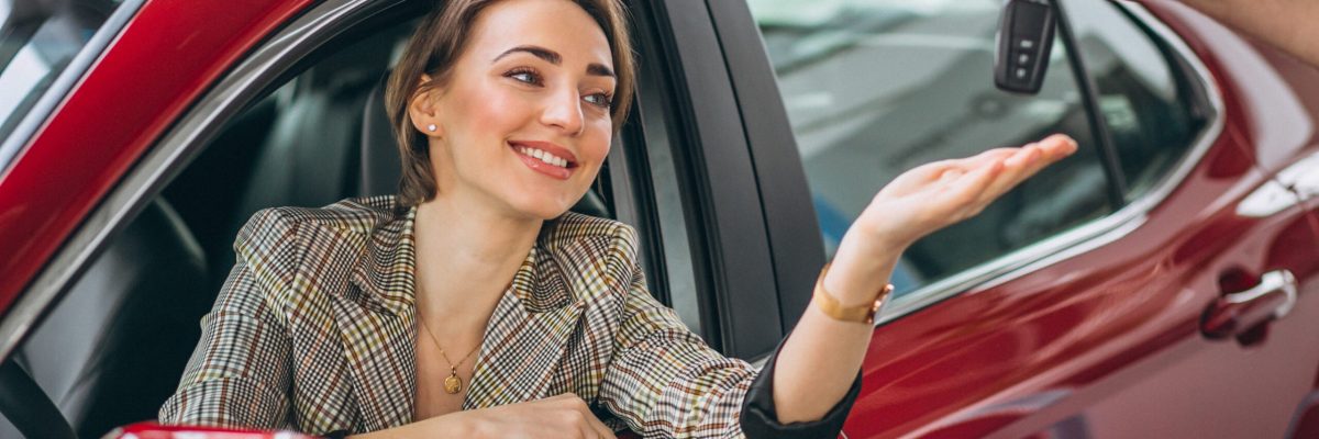 Woman sitting in red car and receiving keys